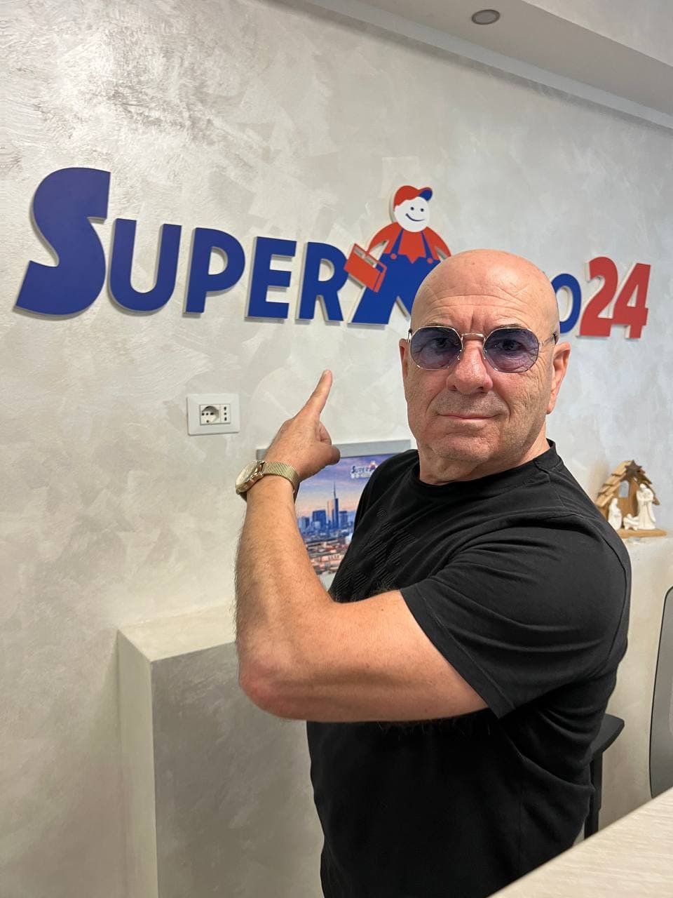 Mario De Filpo indica il marchio SuperMario24 sulla parete del suo ufficio